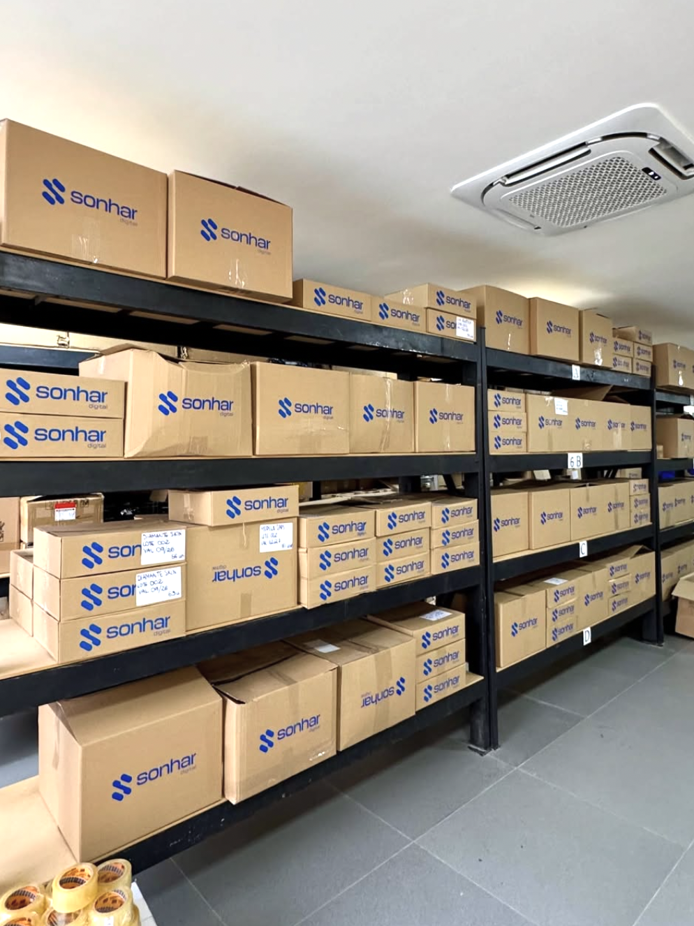 Estoque real da Sonhar Digital com caixas organizadas em prateleiras para separação e expedição